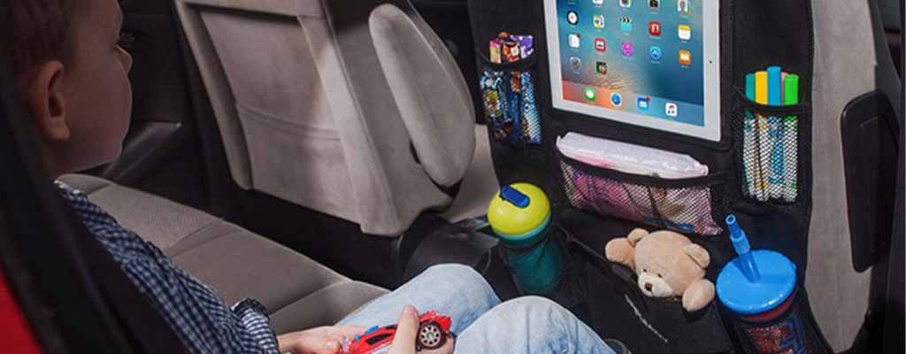 Fotografija prikazuje otroka v avtosedežu, ki ima organizator na avtosedežu.