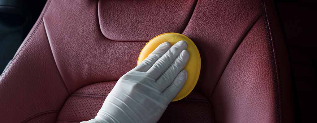 Fotografija prikazuje čiščenje usnjenih sedežev in sredstvo za vzdrževanje usnja, ki ga izvajajo v Avtocentru Avtostop v Ljubljani.