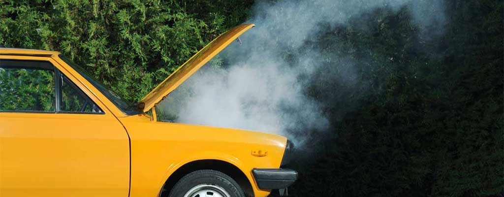 Fotografija prikazuje okvaro avta, ko se pokvari katalizator ali zakuha motor avta.