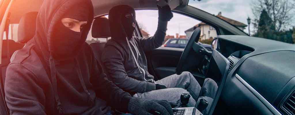 Fotografija prikazuje tatova na delu, ko kradeta avto.