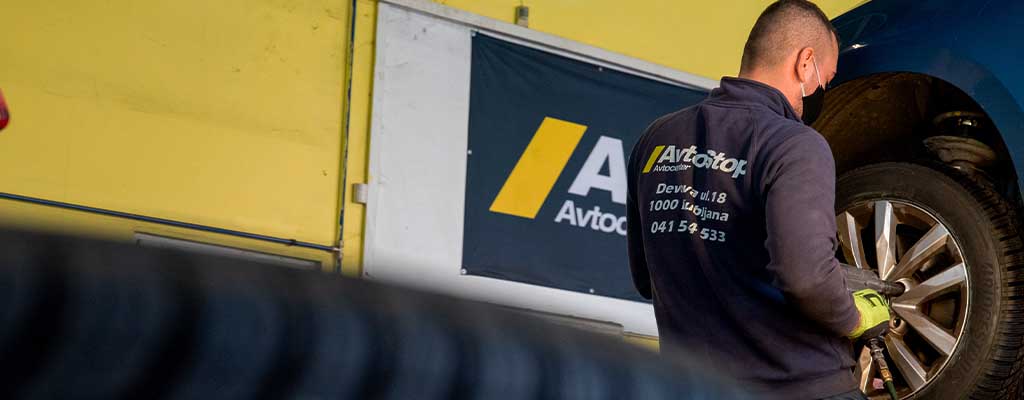 Fotografija prikazuje menjavo gum, ki jo opravlja vulkanizer v Avtocentru Avtostop v Ljubljani.