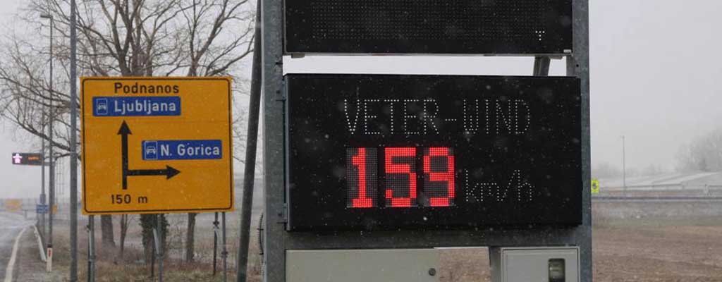 Fotografija prikazuje moč vetra na primorski cesti.