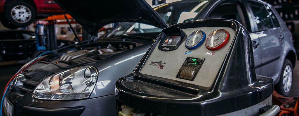 Fotografija prikazuje avtomobil med polnjenjem in servisom avtoklime, ki ga po ugodni ceni opravljajo v Avtocentru Avtostop v Ljubljani.